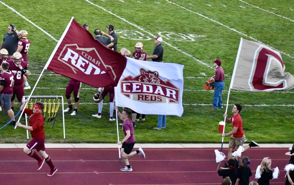 boys carrying Cedar Reds flags