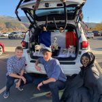 Students showing off Halloween decorations in the back of a car