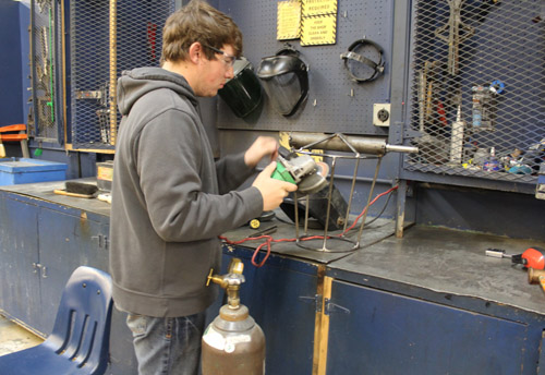 student working on a machine in shop class 