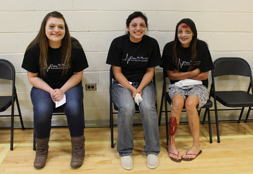 students smiling for camera sitting in folding chairs in the gym 
