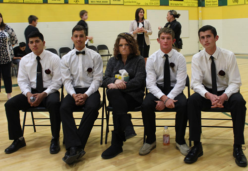 students with a teacher dressed up in gym for a school dance