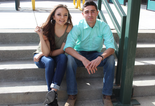 male and female student sitting next to each other on stairs outside and smiling for camera 