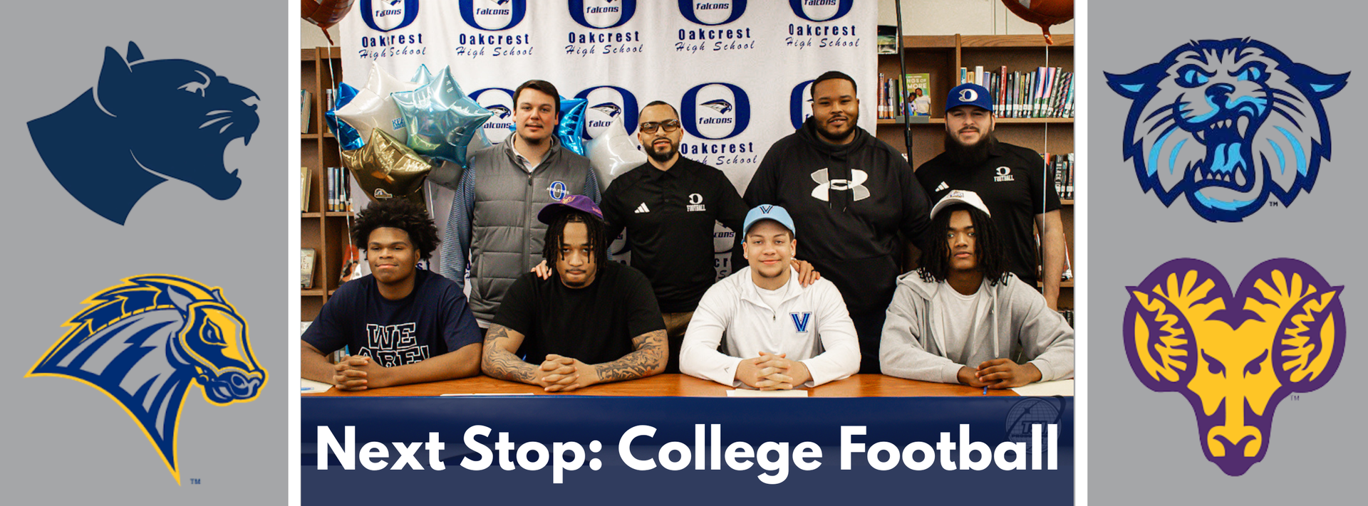 A group of people pose together for a photo. They sit and stand behind a table.