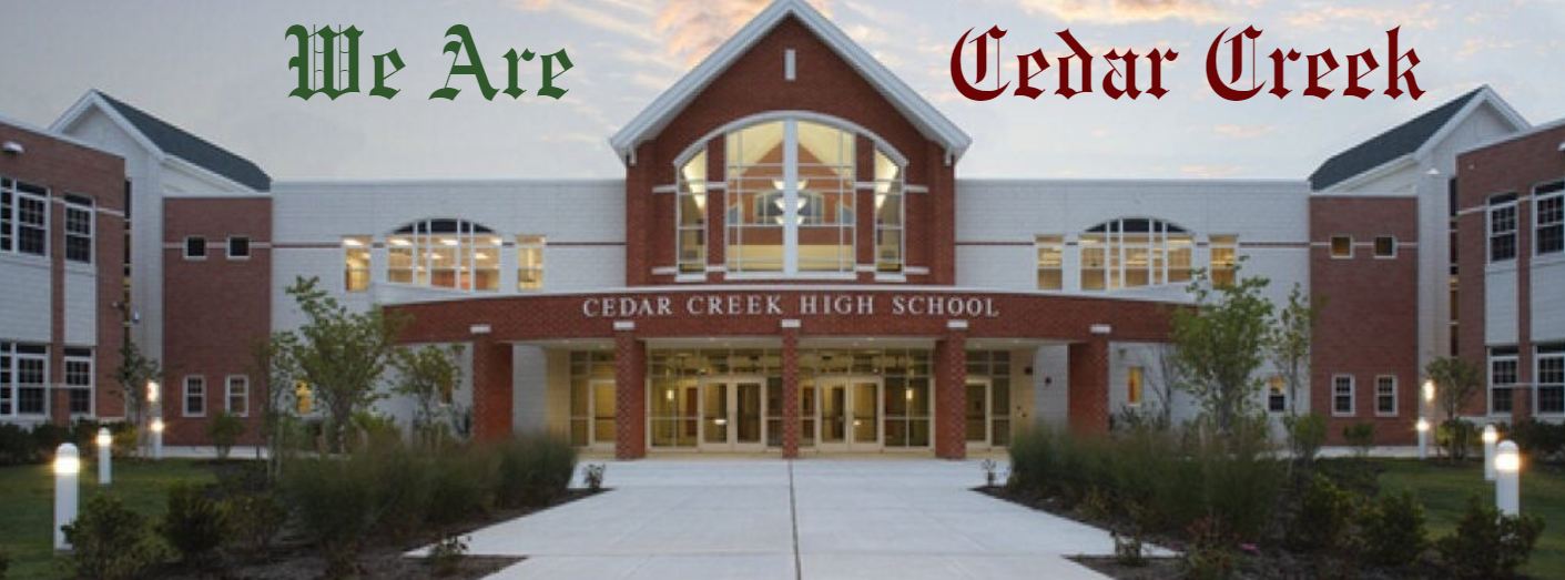Front entrance of Cedar Creek School with walkway, large arched windows, and plants. Text "We Are Cedar Creek" above entrance.