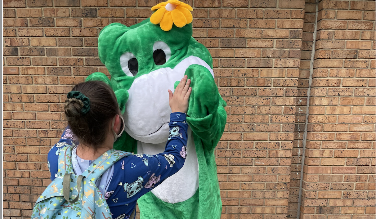 student giving high five to freddie the frog costumed adult