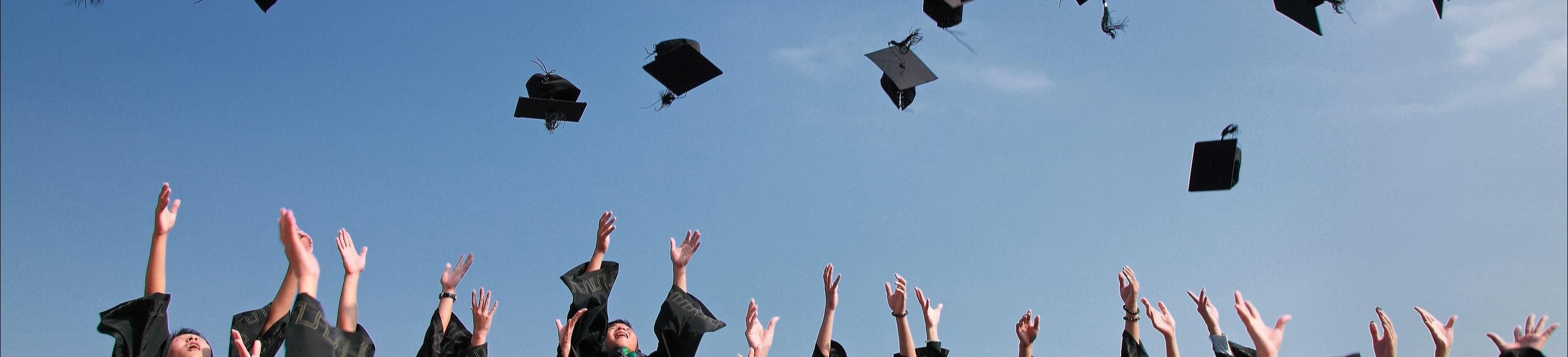 Graduates throwing their graduation caps in the air