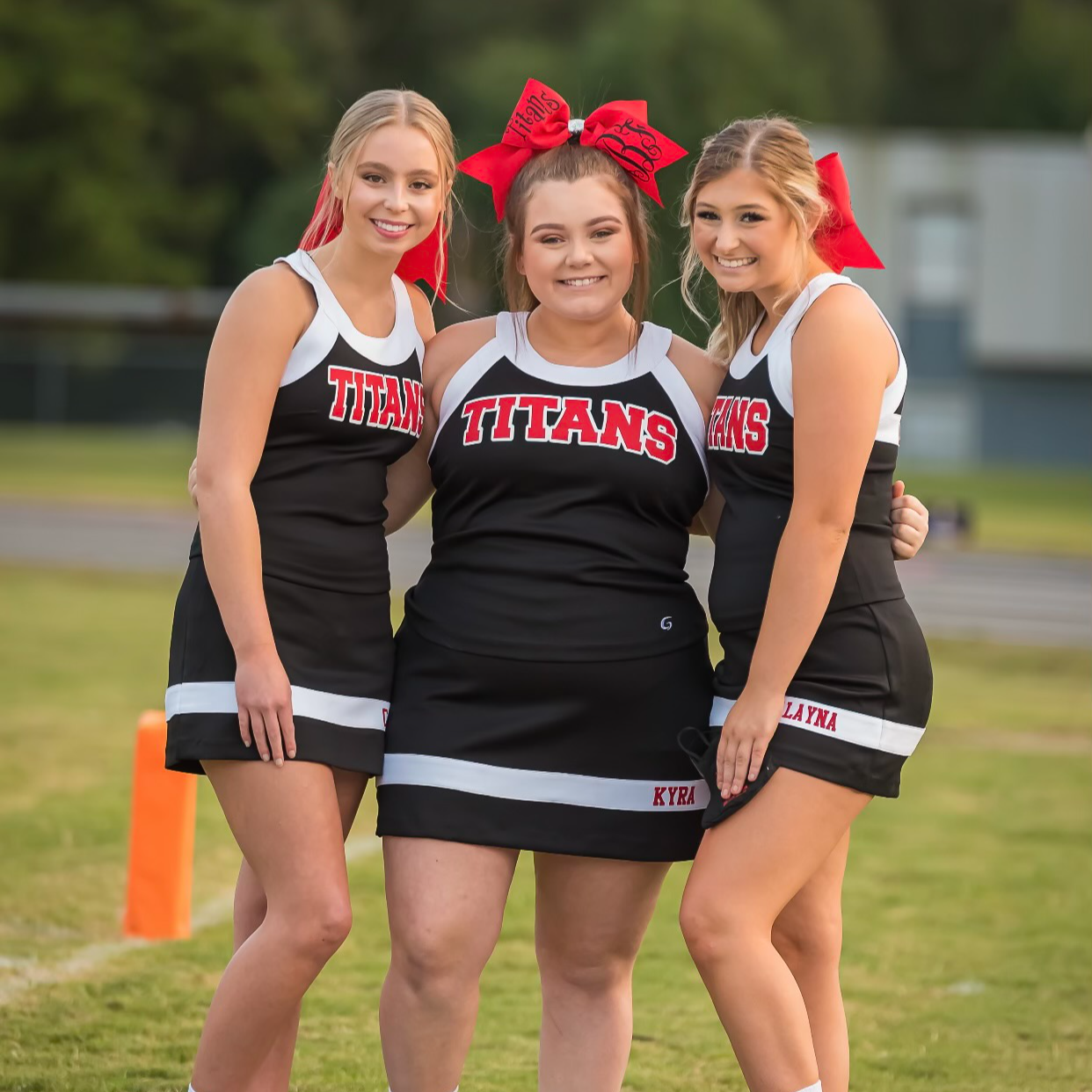 3 cheerleaders posing for a picture