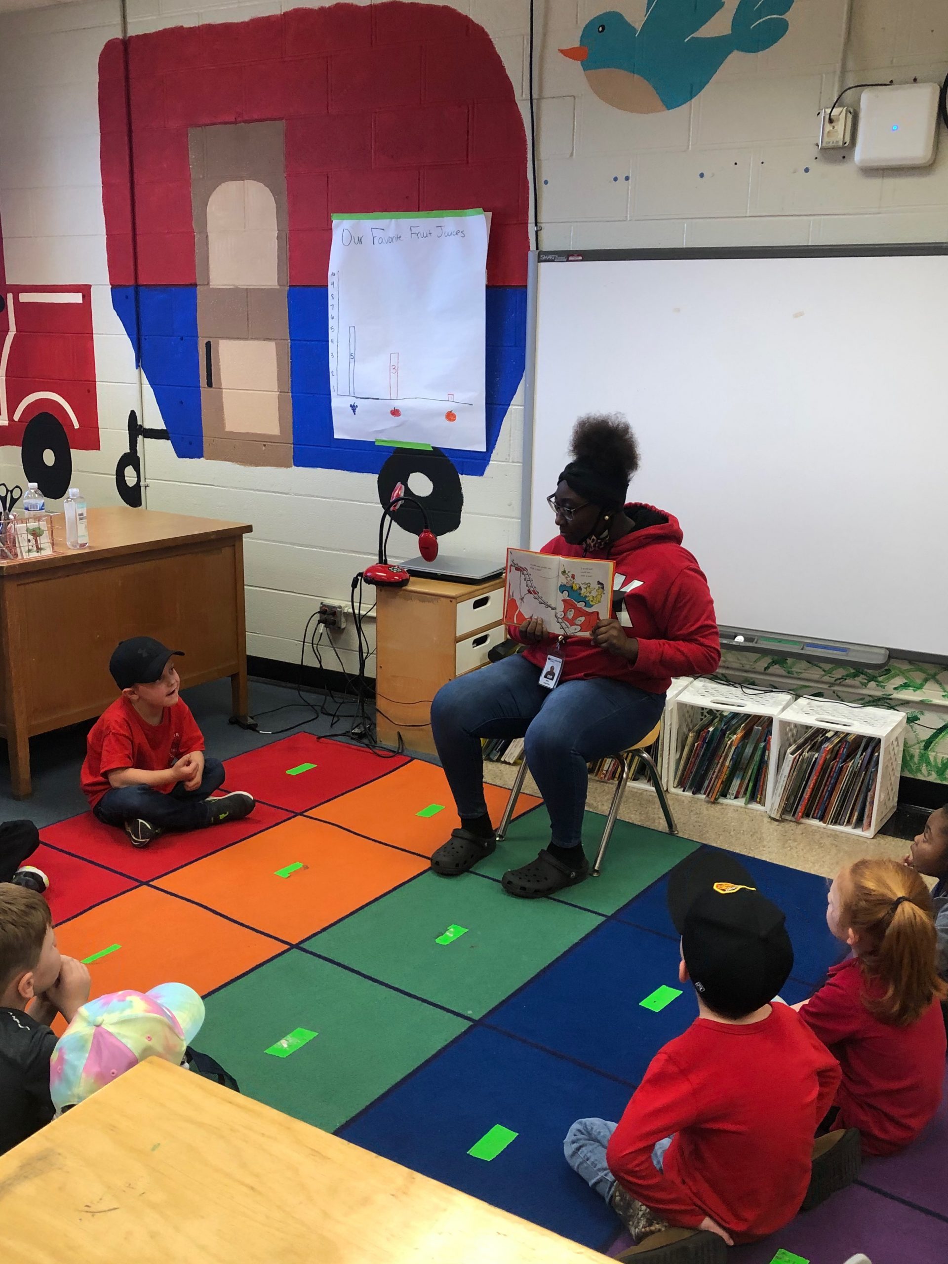 A high school student reading to elementary students