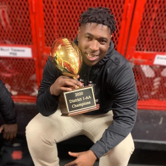 Athletic student holding a football trophy