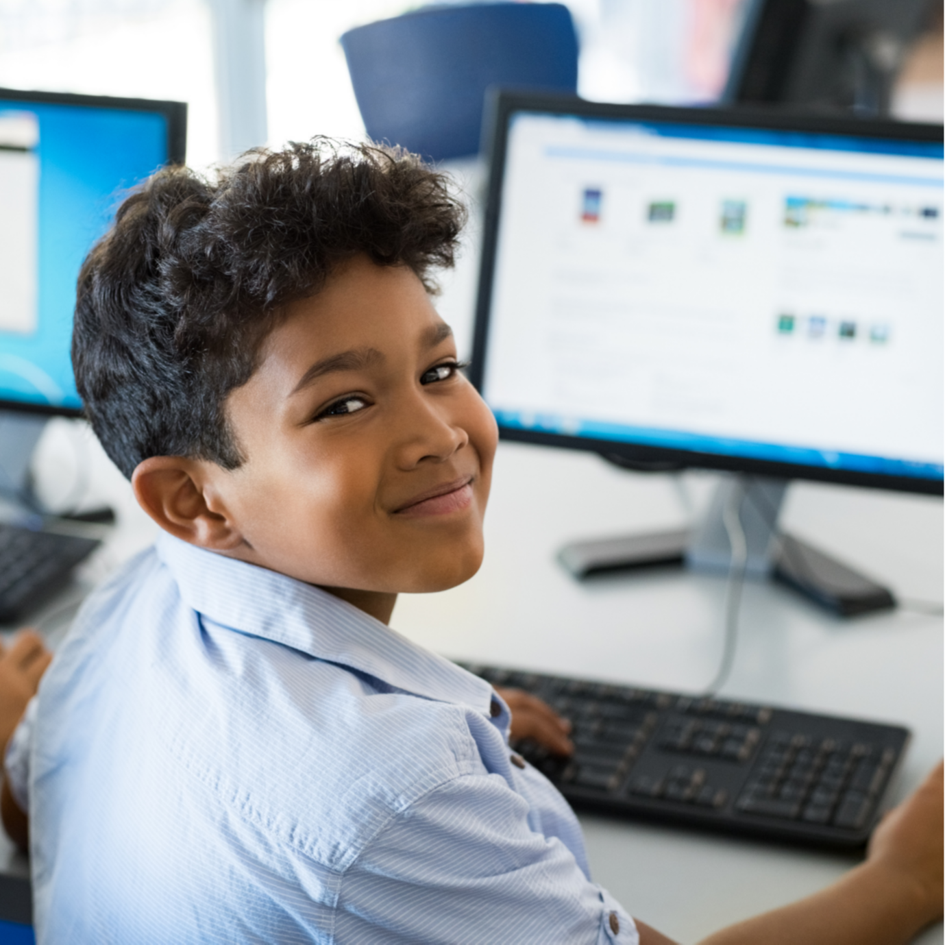 student smiling with computer in the background
