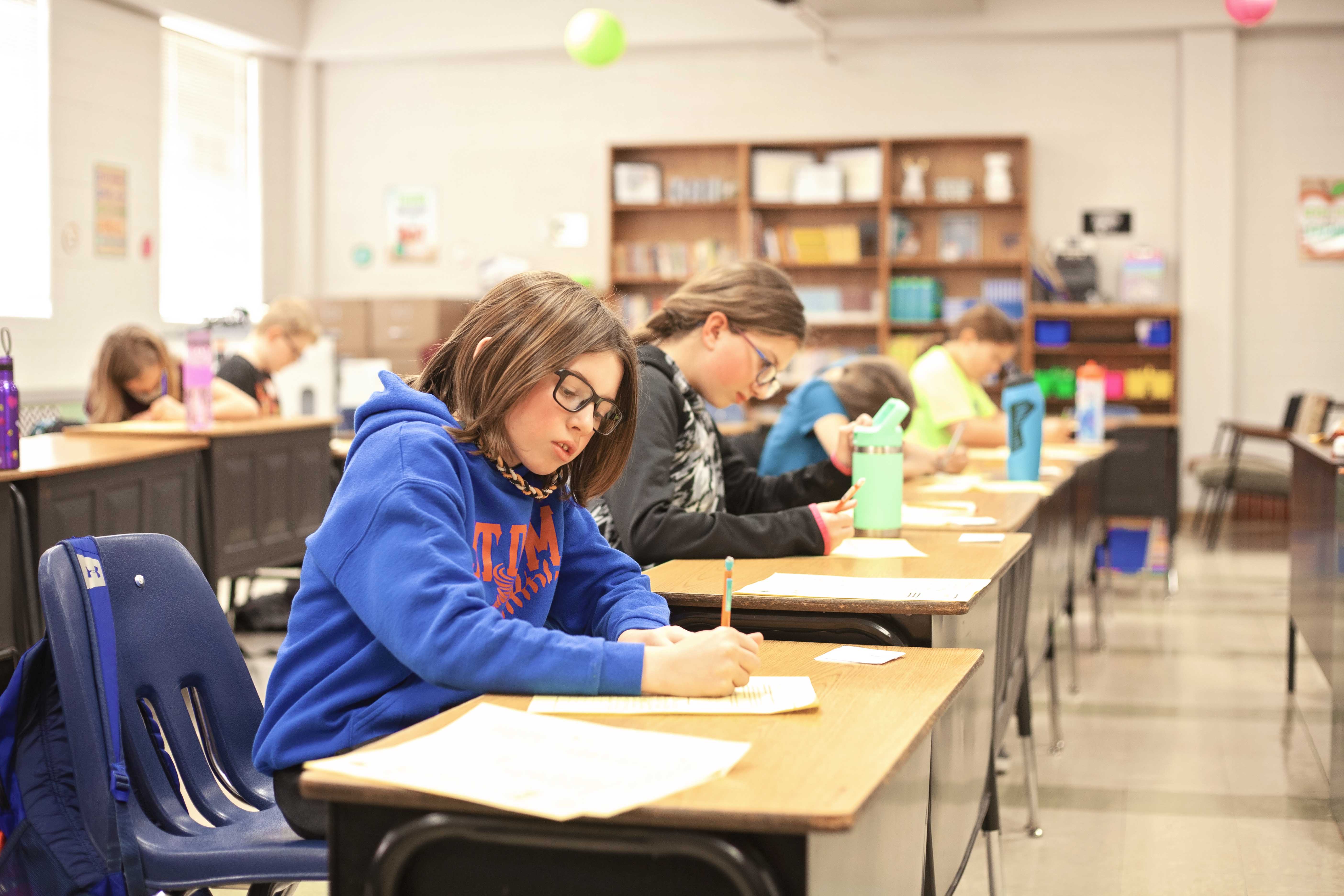 Middles School English students working at their desks in the classroom.