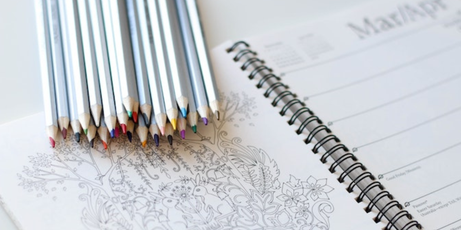 colored pencils by a coloring book