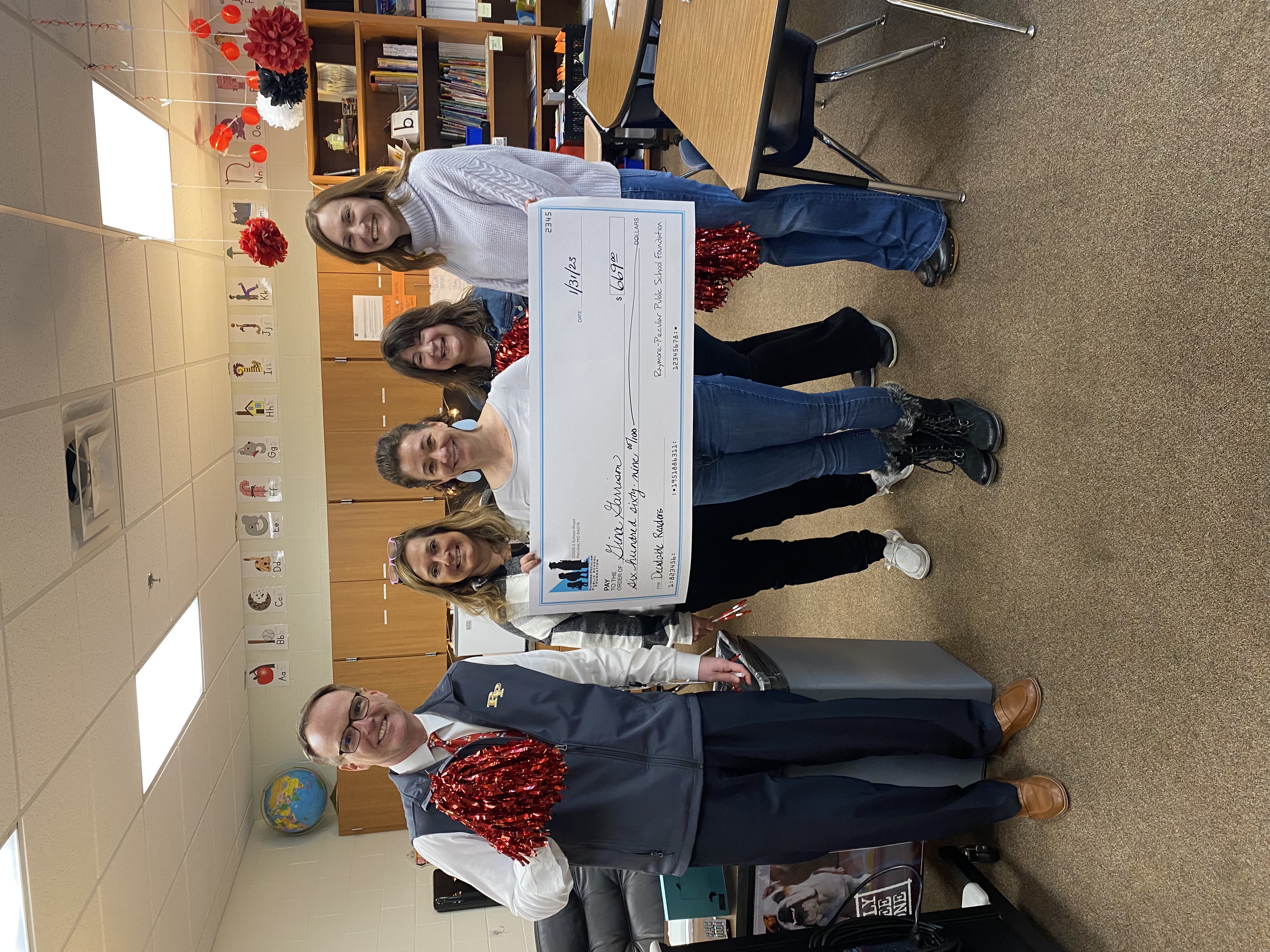 Bridle Ridge Reading Interventionist Gina Garrison holds a giant check