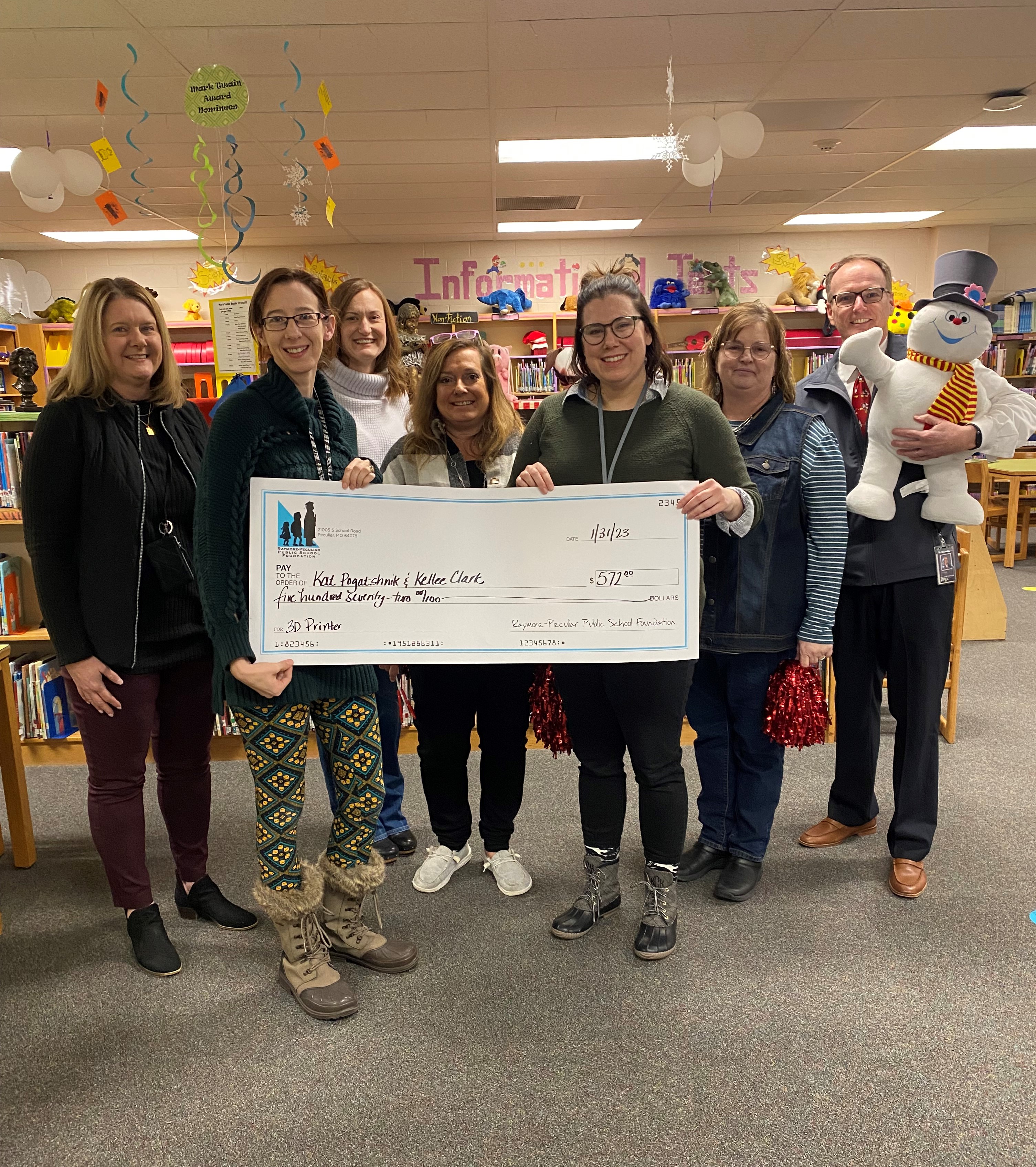 Raymore Elementary staff holding a giant check