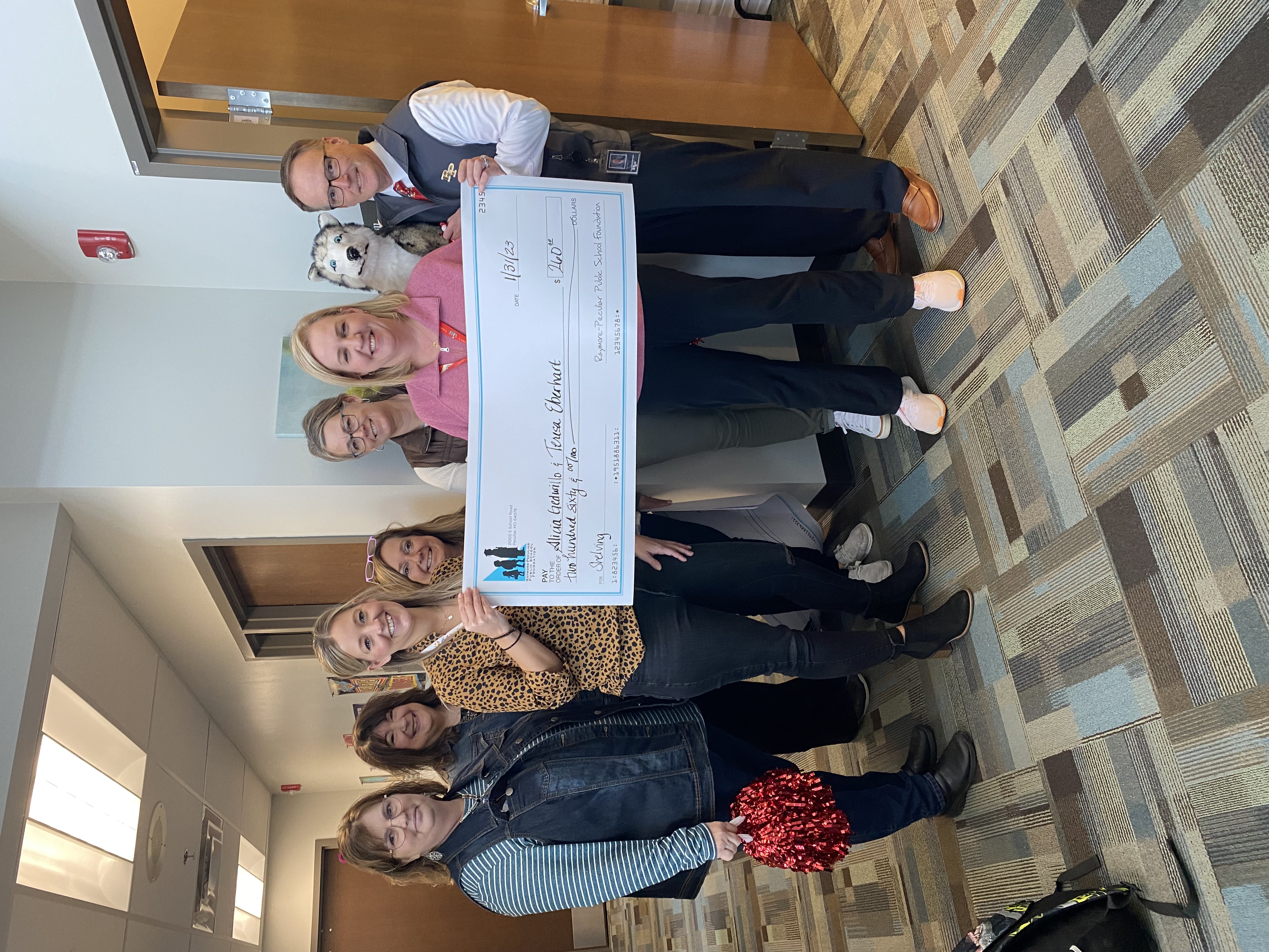 RPEMS staff hold a giant check