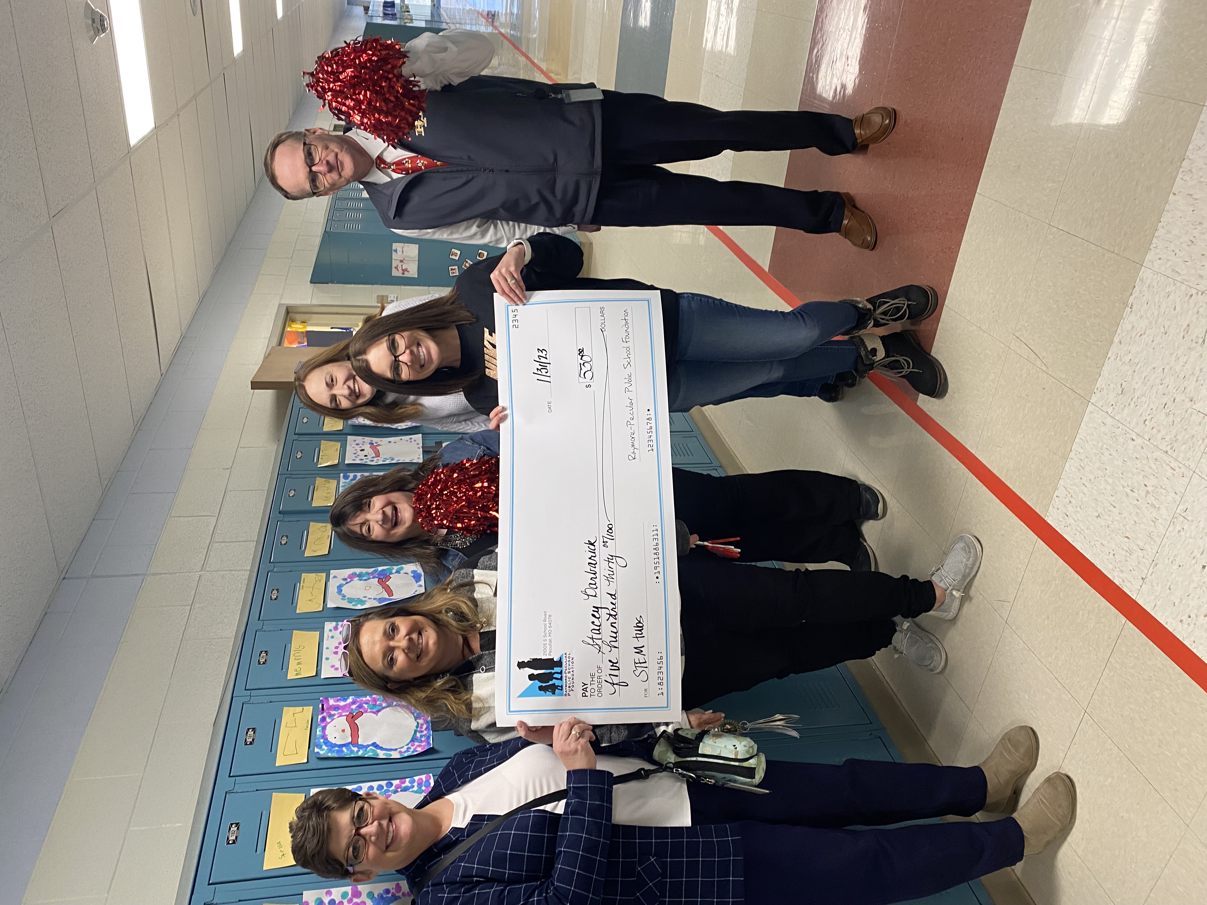 Shull Teacher Stacey Barbarick holds a giant check