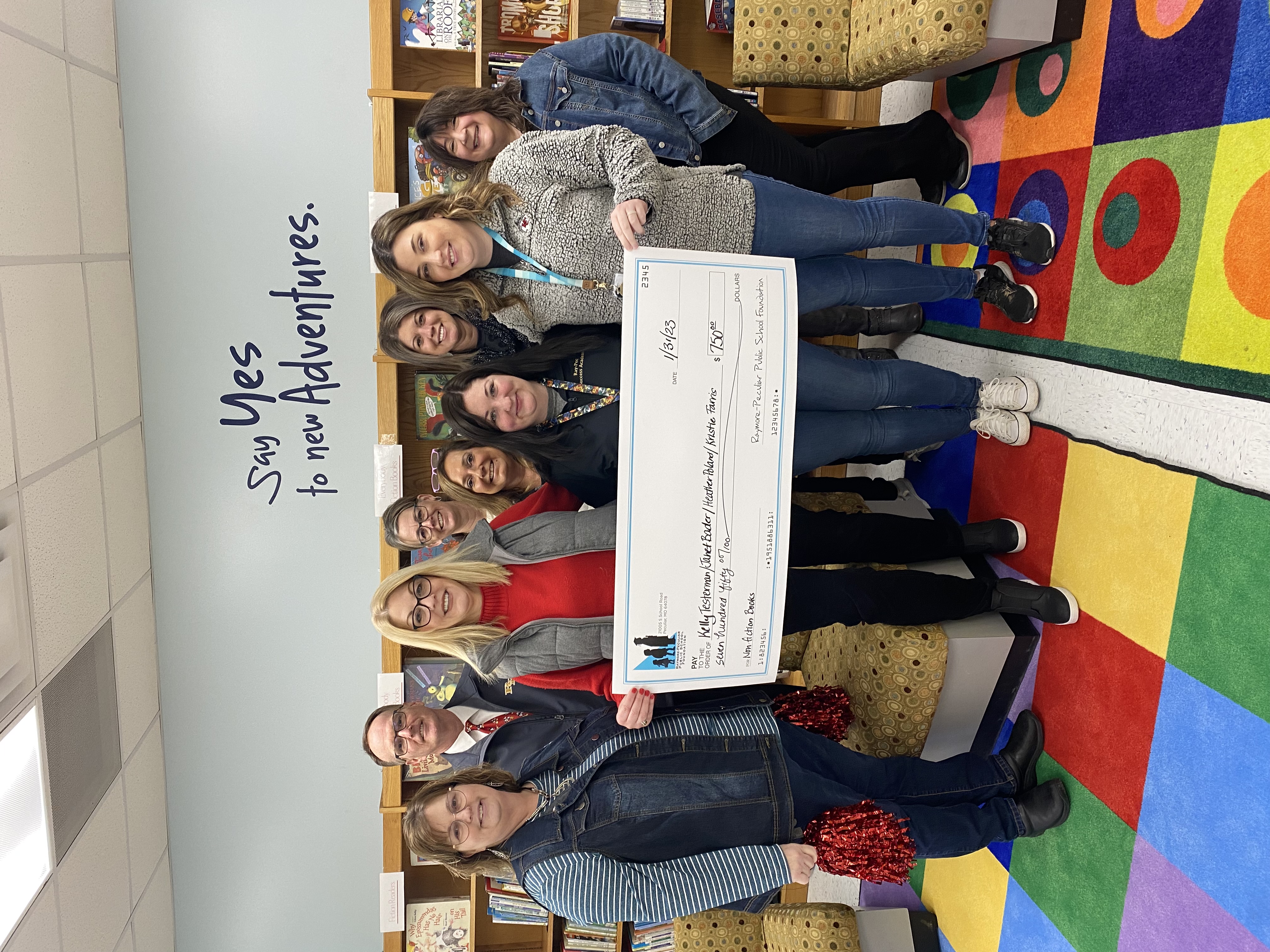 Success Academy staff hold a giant check