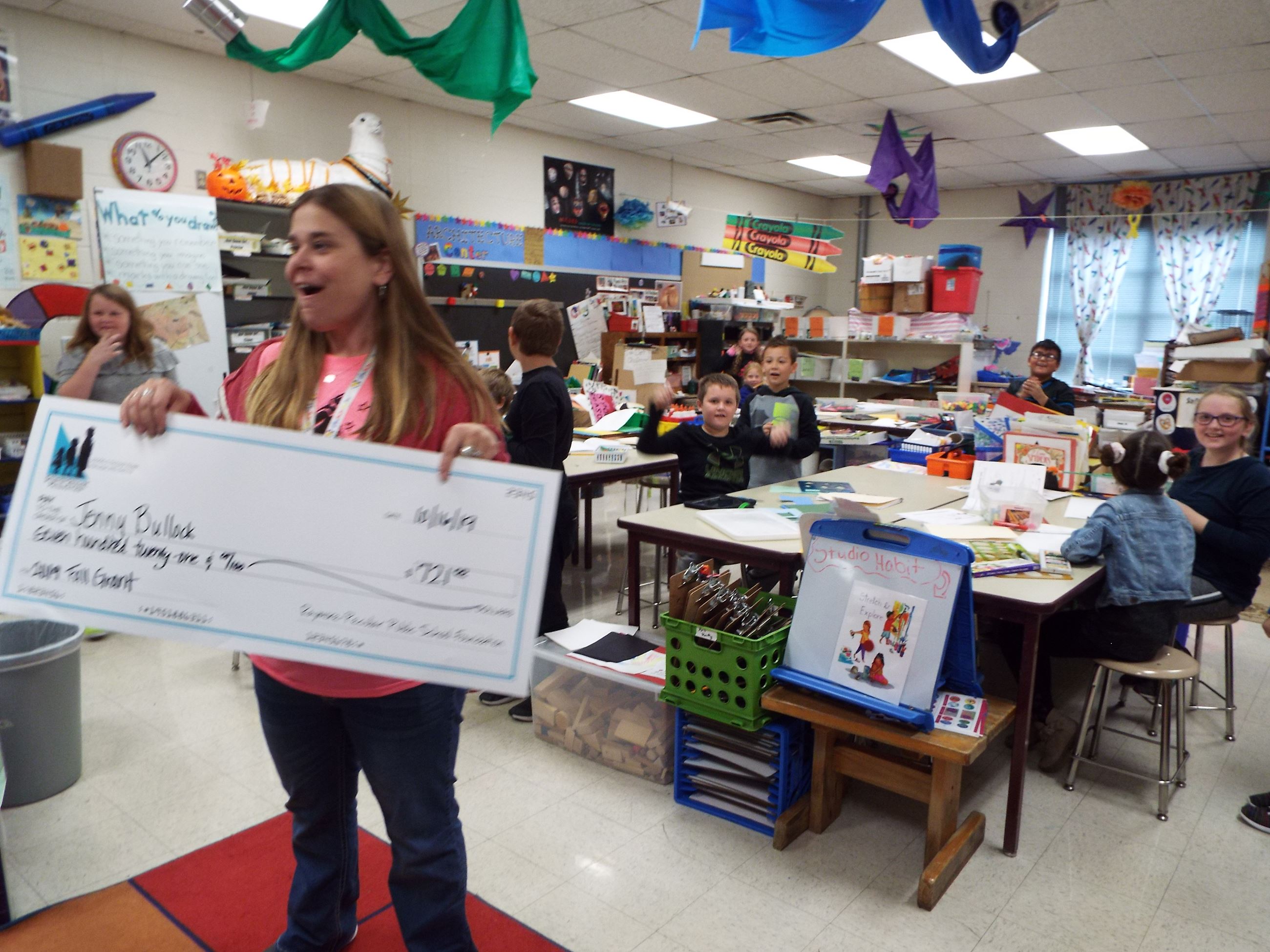 Peculiar Elementary School Art Teacher Jenny Bullock reacts when she is presented a grant for $721 to purchase LEGOs to incorporate into mosaic art projects.