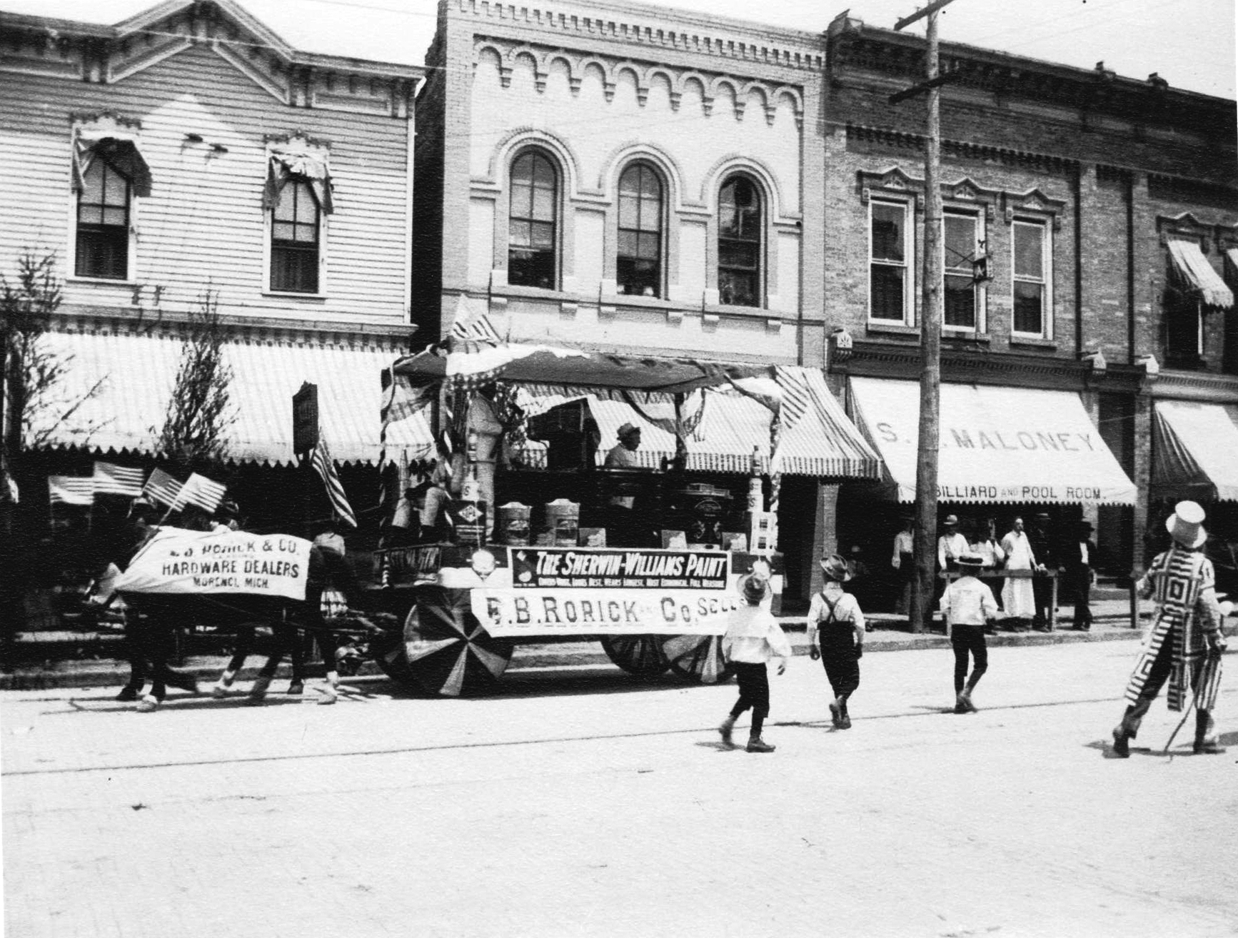 W. Main Street, Morenci, Michigan (north side).  Spence Maloney’s Saloon, E. B. Rorick & Co. Parade float – after 1902 (in front of present-day Sipel Bldg., 224 W. Main)
