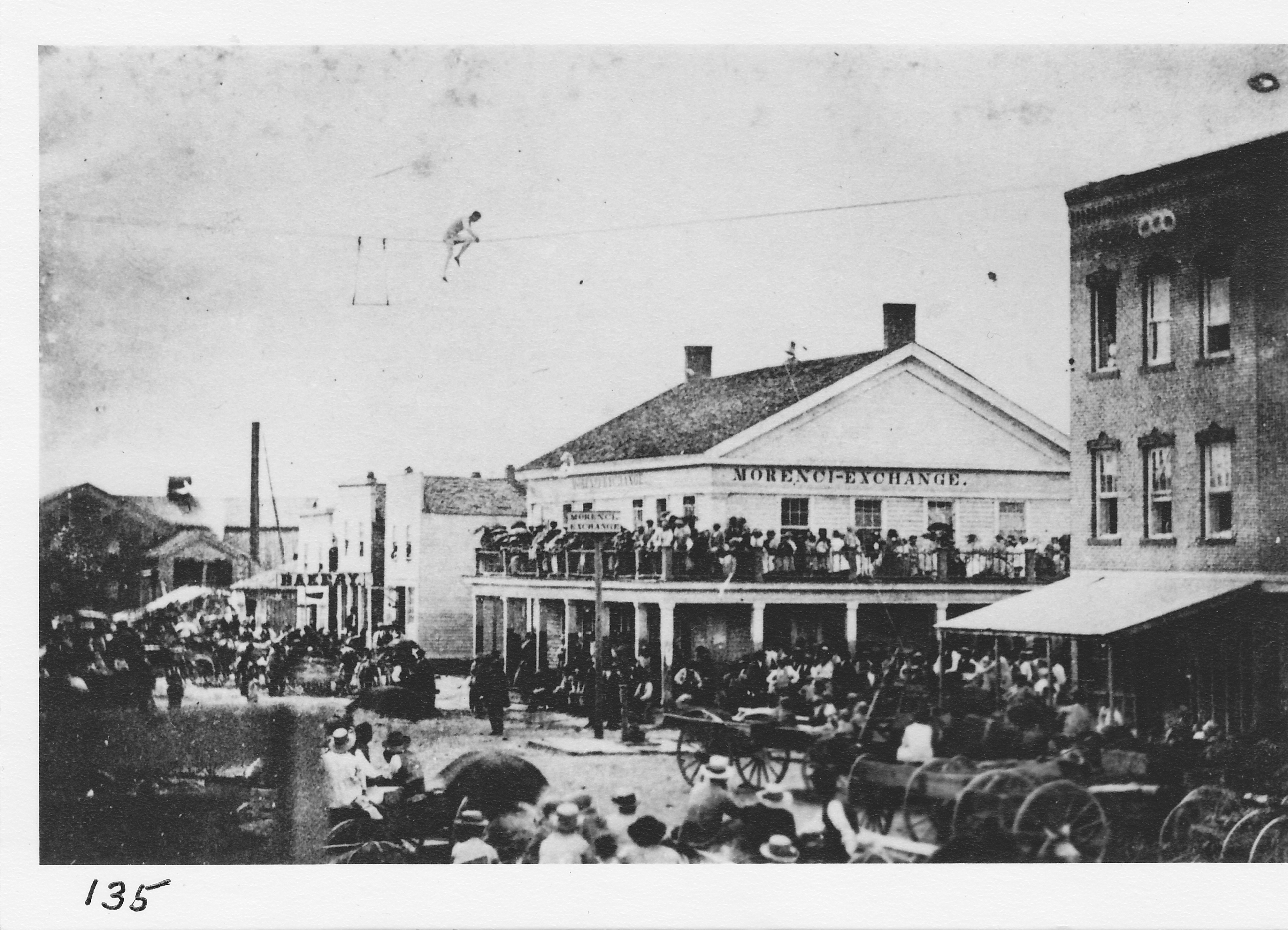 Morenci Centennial celebration July 4, 1876.  Abram Babcock is walking a tight-wire from the bank to the Mace building.  Morenci Exchange is on northwest corner.