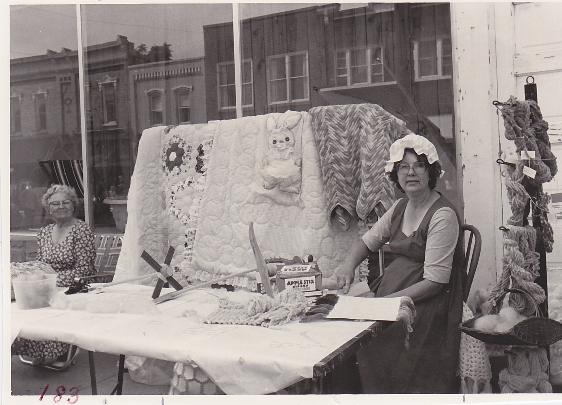 Mrs. Richard Rhoads (Aldora) with her mother, Mrs. Ceil Keefer, Arts and Crafts booth demonstrating “carding.” Town and Country Festival, August 15 and 16, 1980.