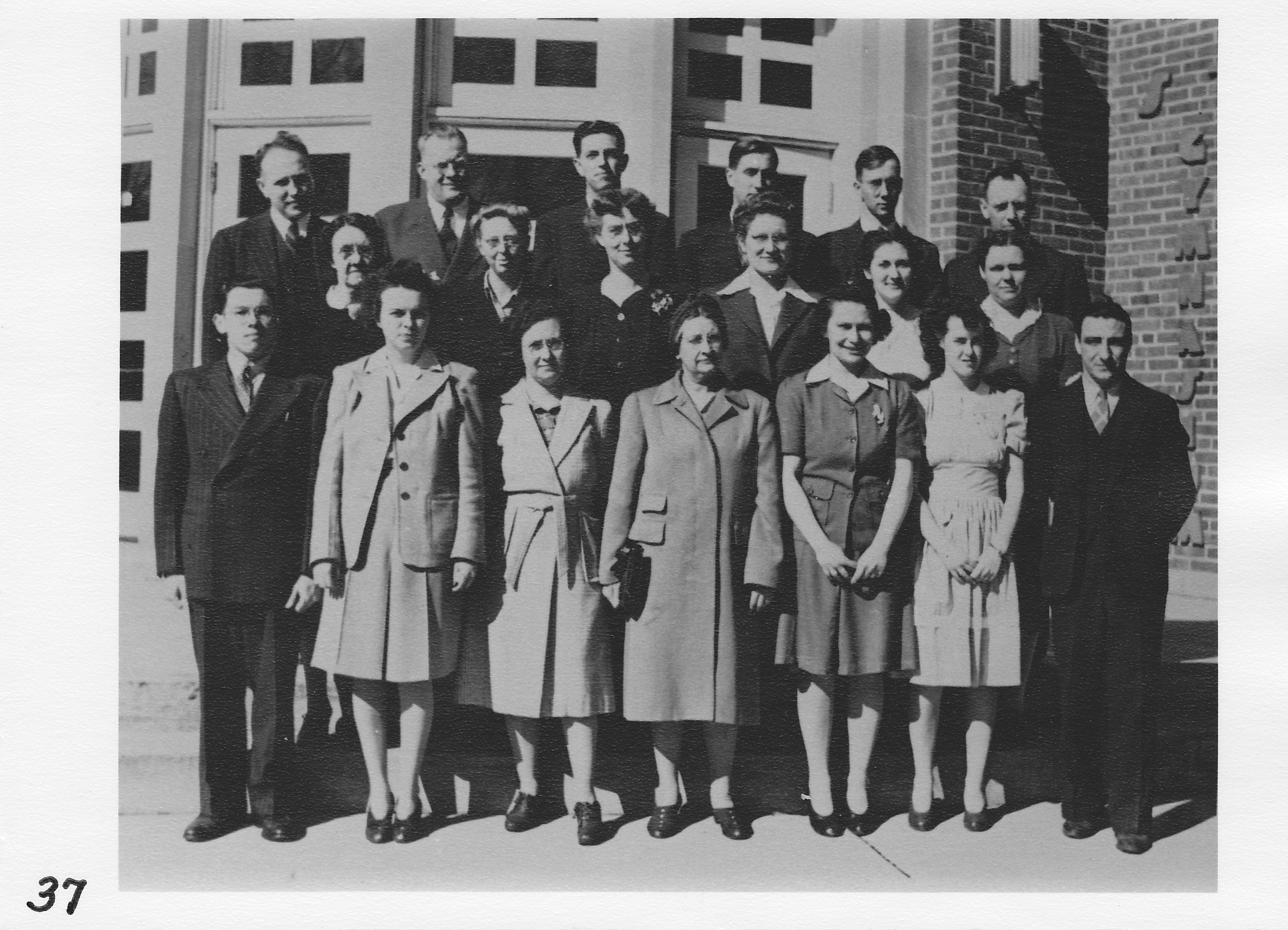 Morenci High School teachers in front of Stair Gymnasium.  Photo about 1943.  Top row (l-r) Henry Geisler, ______________, Ross Cox, ______________, Lyle Eggleston, Rex Riley.    Middle row (l-r) Hattie Lang, ______________, Gertrude Van Havel, ______________, ______________, Catherine Garrow.  Front row (l-r) _____________, Rita Chappell, Marie Johnson Butler, Minnie Green, ______________, ______________, ______________.