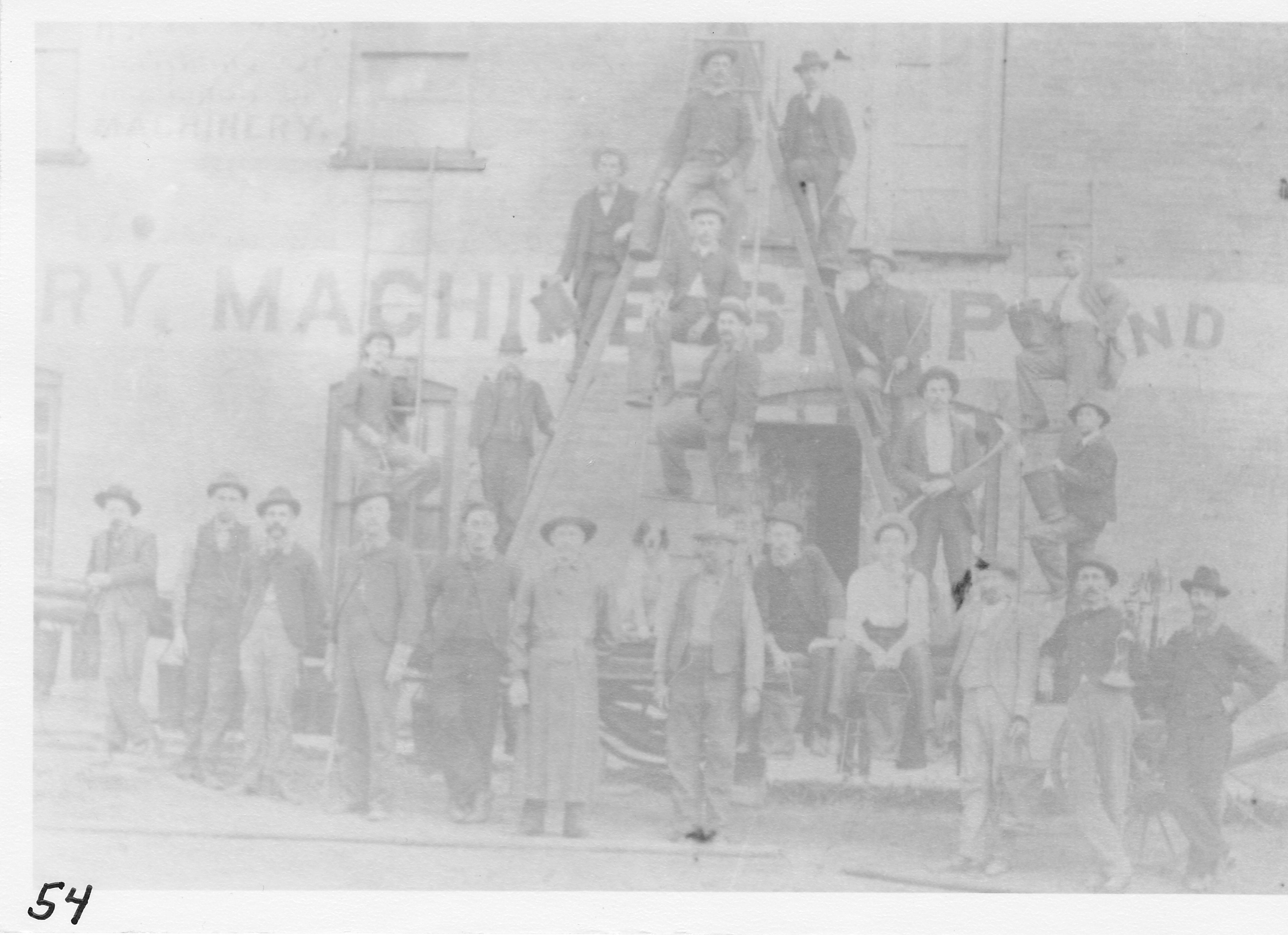 Hook & Ladder Company, Morenci Fire Department, organized in 1871. See photo #153.   Front row (l-r) Bill Price, Dan Goodyear,   Perry Warner, Theo Drake, Bert Beck, Tom Cochran, Leander Baker, Walter  Armstrong, Bert Osgood, Wm. Metcalf, Wm. Drake, Bill Royce. Dog is Leander Baker’s.  Single ladder on left – Newell Covert.  Left center ladder, top down – Cliff Willis, Ed Smith.  Center ladder, top down – George Kimes, Orin Miles, Bert Beaverman.  Right center ladder, top down – George Glazier, Dan Staniger, Lenn Palmer.  Right single ladder, top down – Vern Whitney, Dell Harmon.