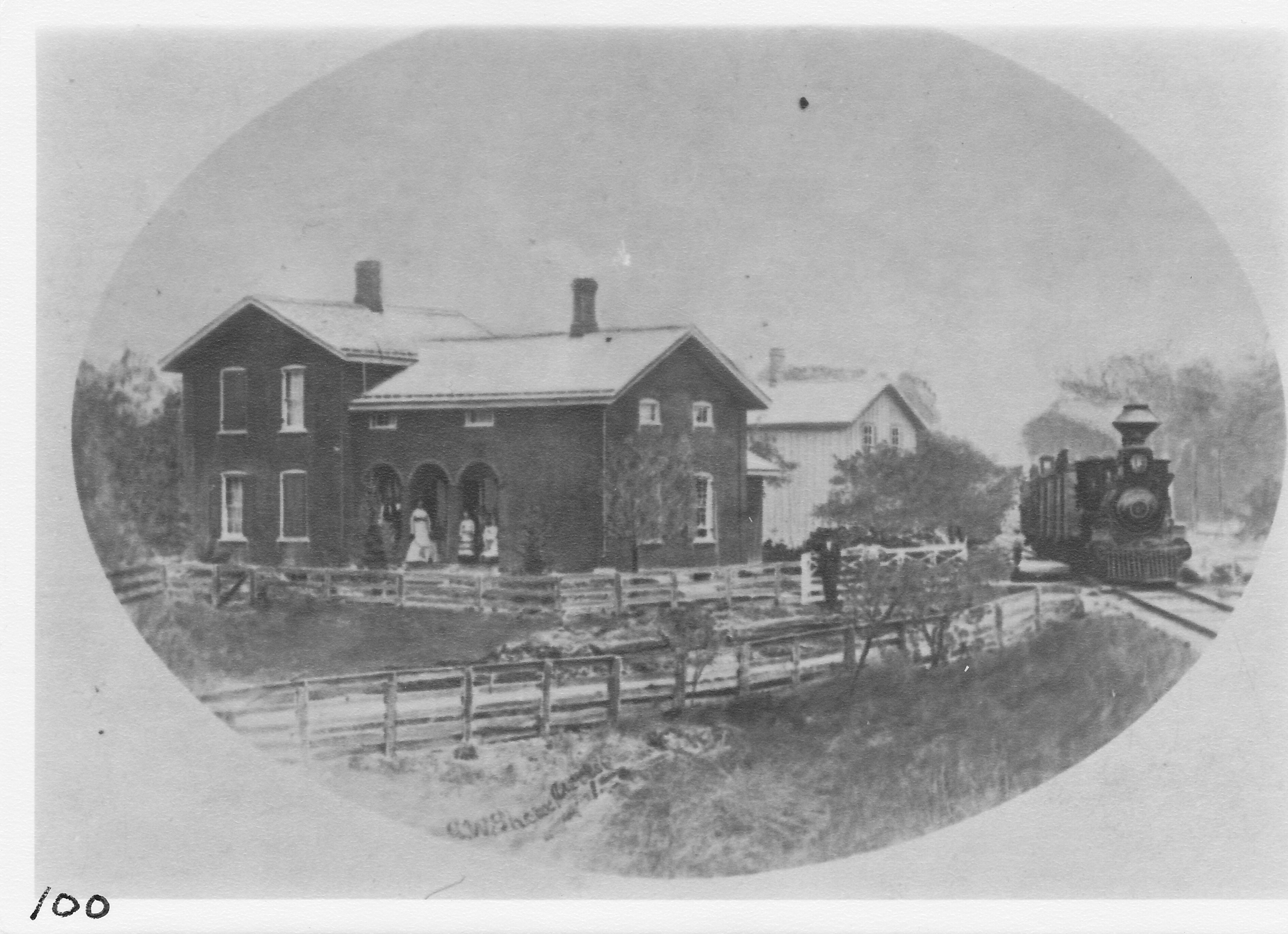 Ritter’s Station on the Chicago & Canada Southern Railway. The brick Ritter home. White building in rear is station with “Old Dolly” heading west to Fayette, Ohio.  (2 miles west and 1 ½ miles south of Morenci)