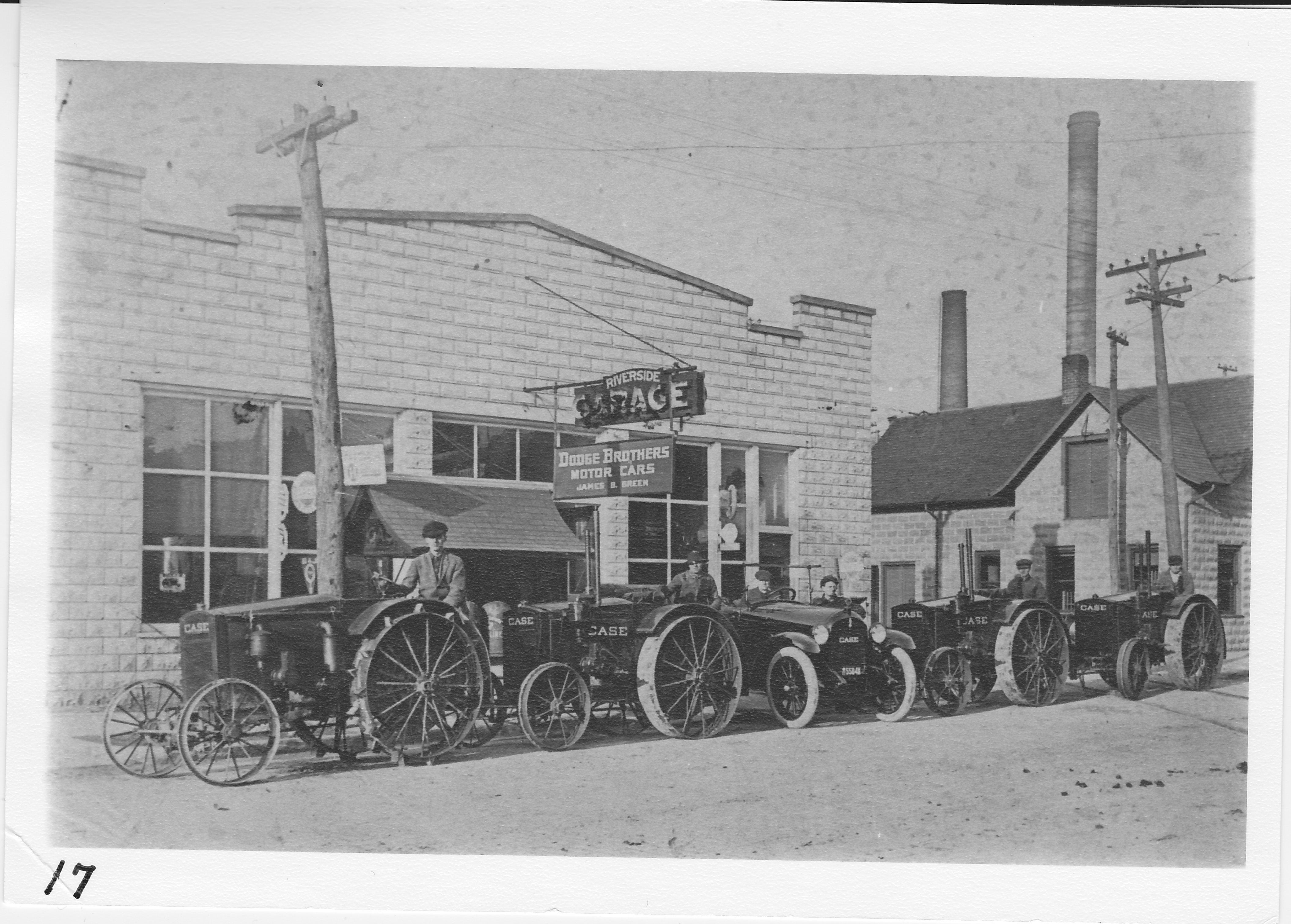 Riverside Garage, James Green owner.  Former roller skating rink north side of West Main Street.  Part of Porter Lumber Company buildings today.  Tractors in front (Trevor Smith in photo).