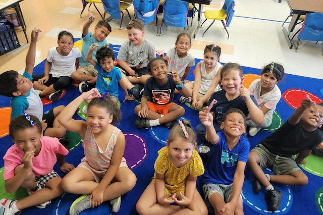 students sit on a rug