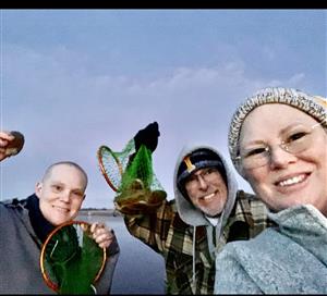 Staff members holding up their clam nets after clamming