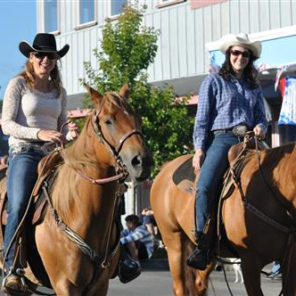 Two staff members riding their horses in the Loyalty Day's Parade