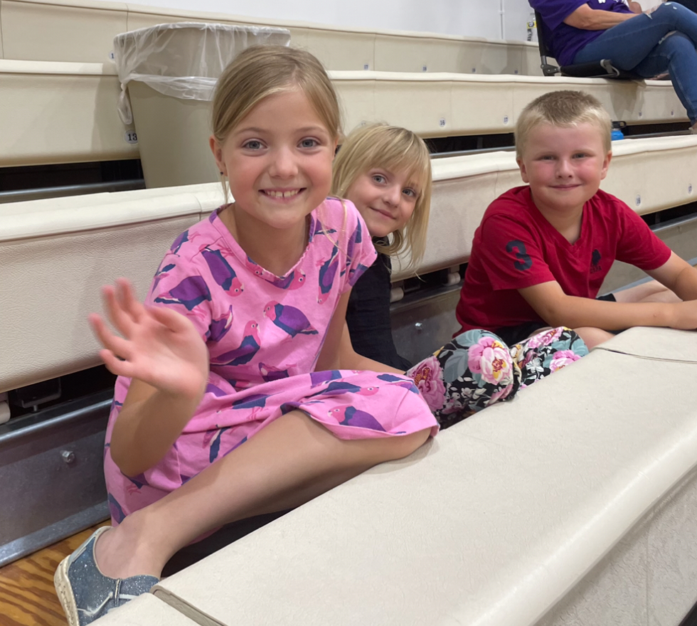 Elementary students watching a volleyball game.