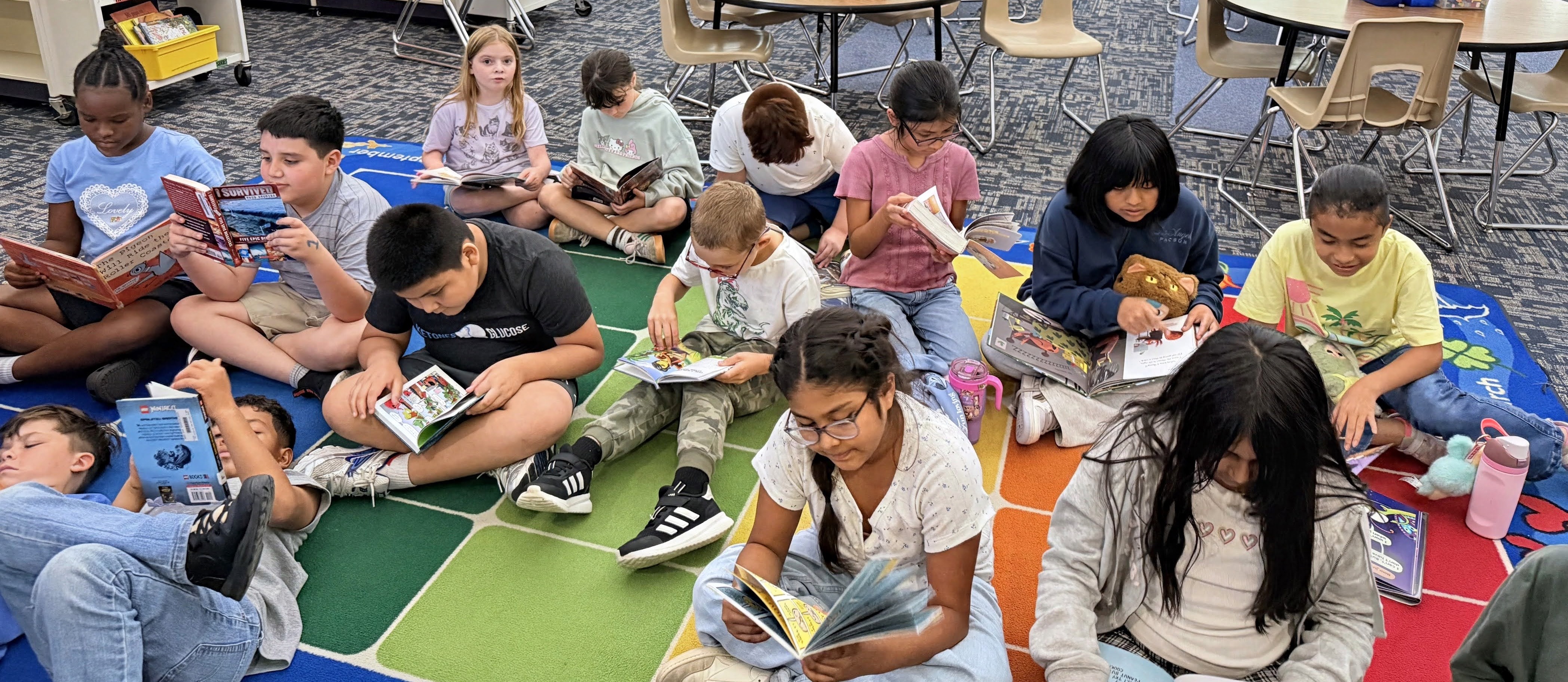 Students reading on the carpet.