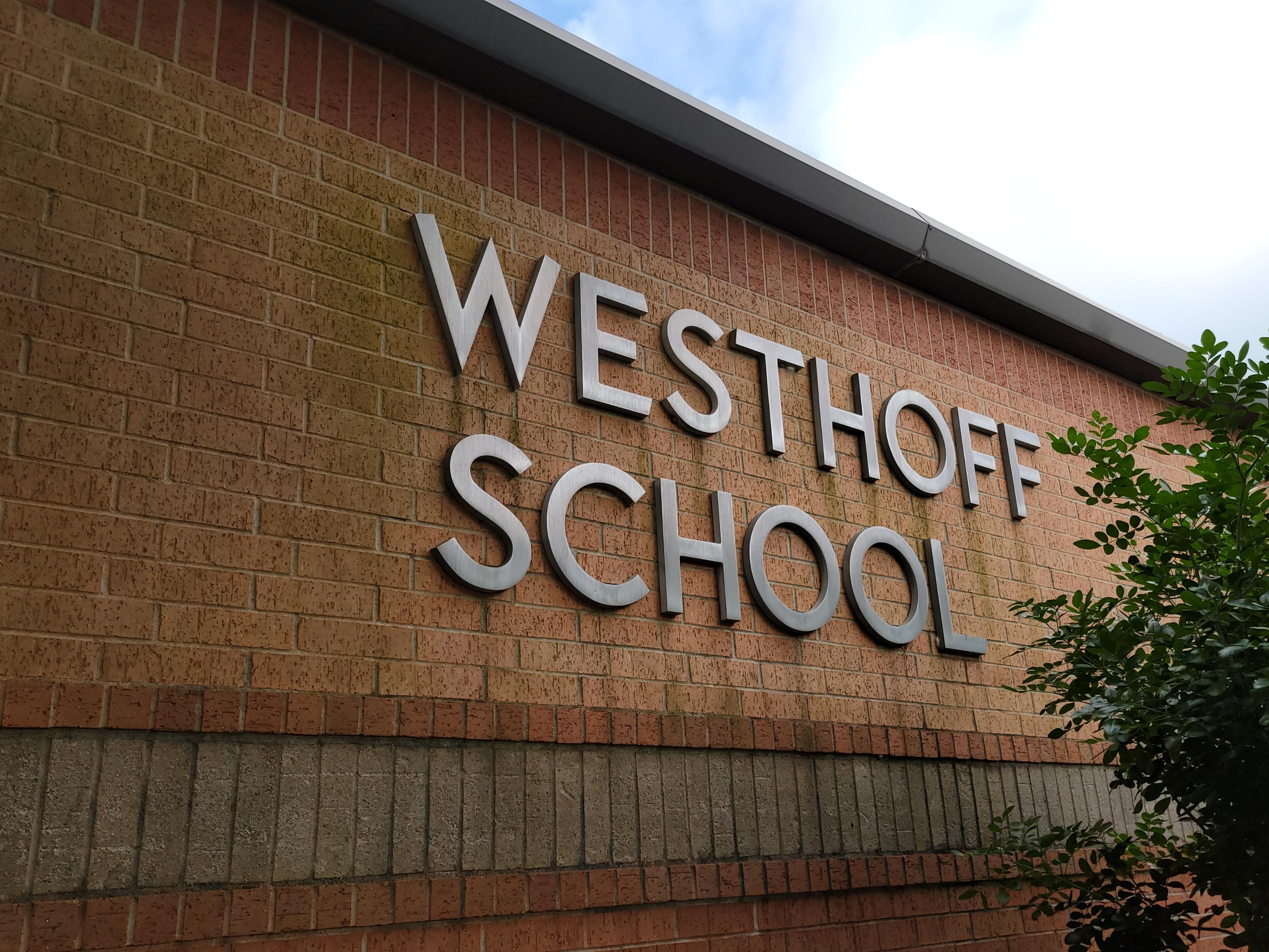A sign with Westhoff School on a wall