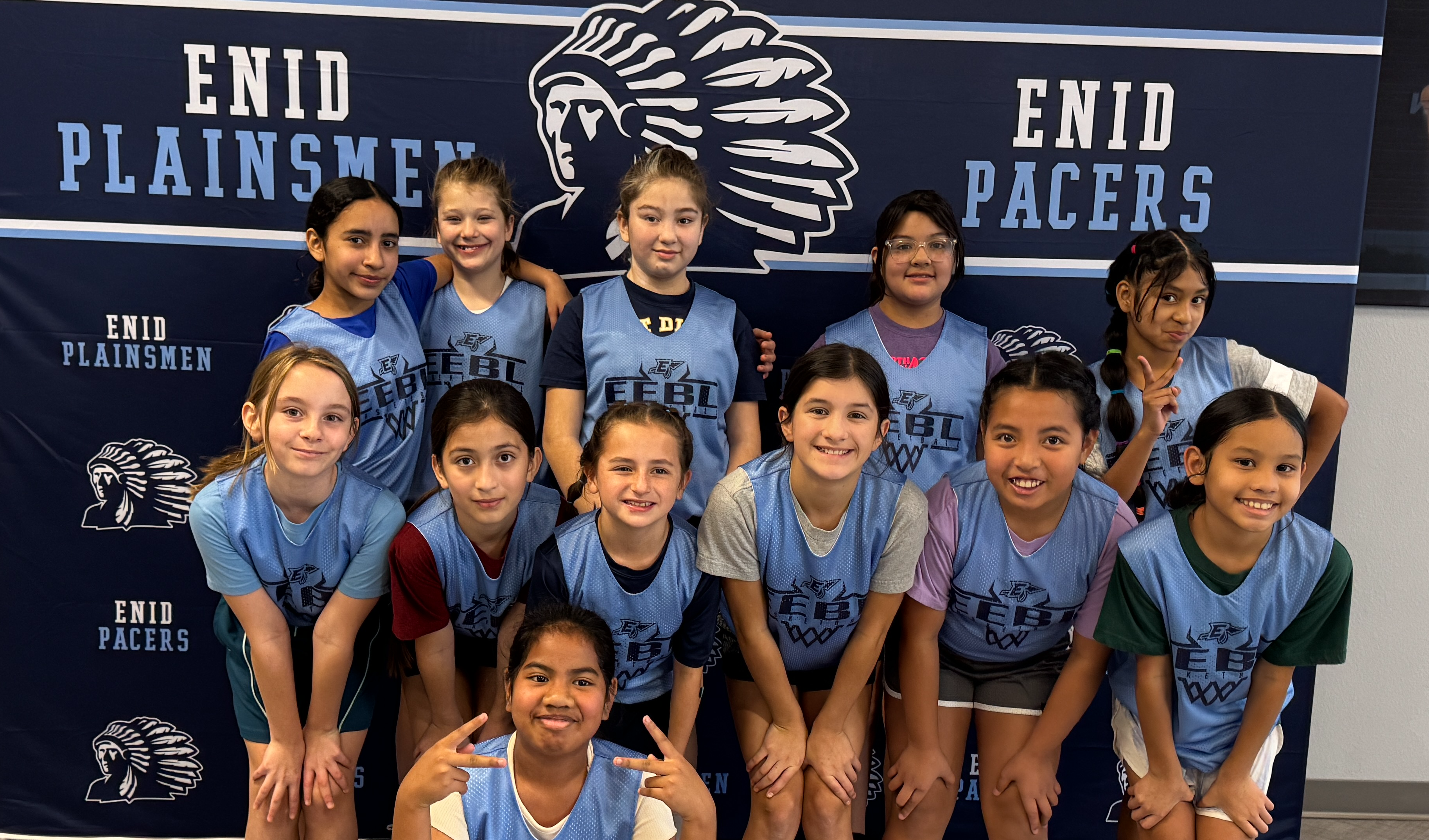 Taft Tiger girls Enid Elementary Basketball League at tournament posing Infront of screen. 