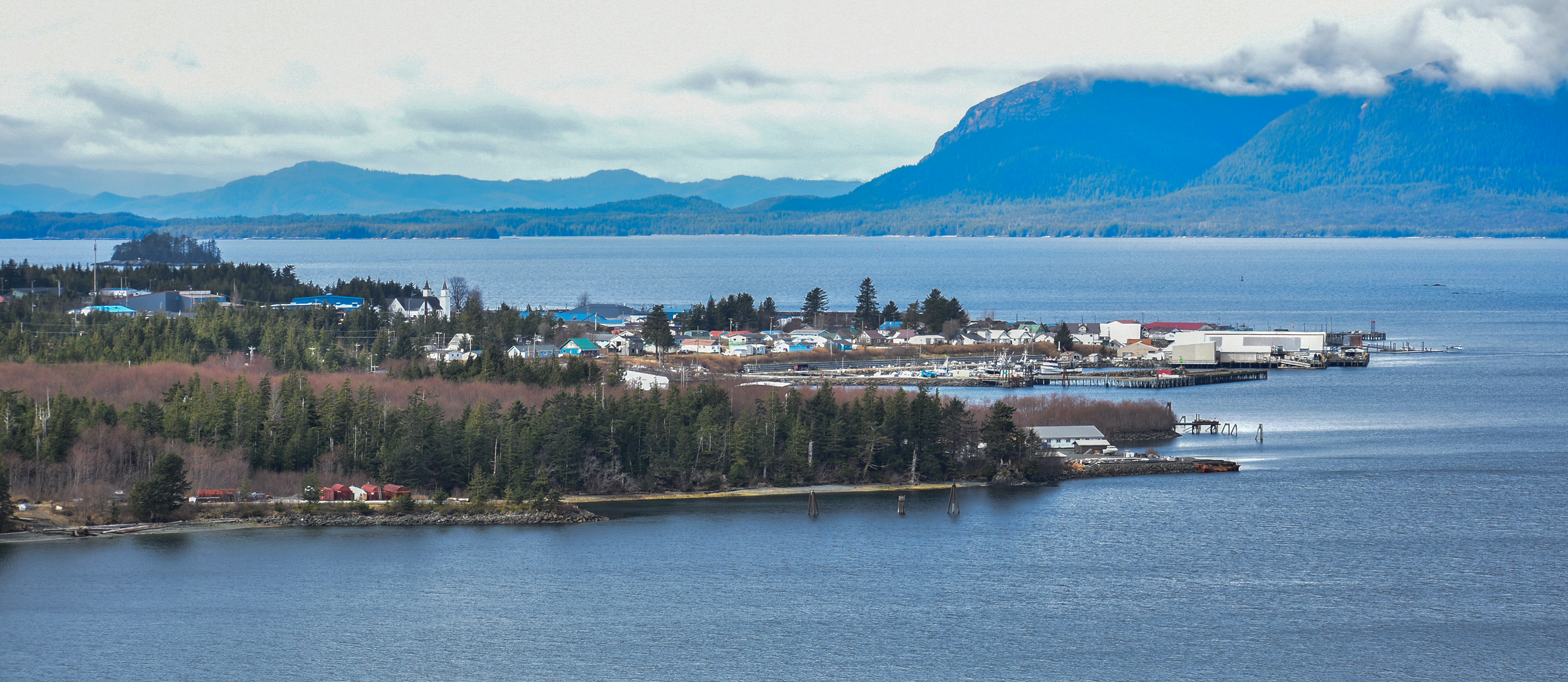 Metlakatla from viewpoint on Walden Point Road.  Island with mountains surrounding it, boats and houses can be seen