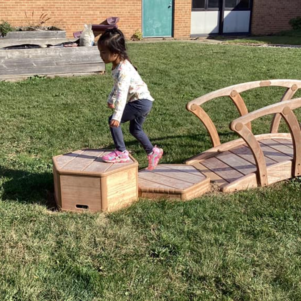 child on wooden step stones