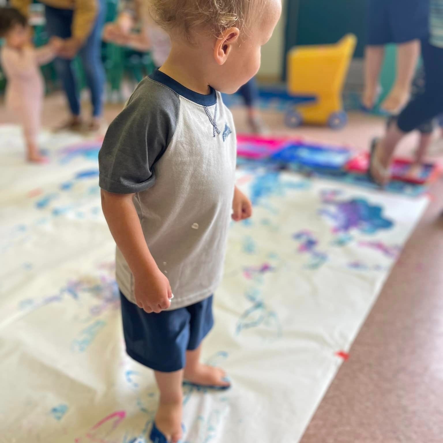 child painting canvas with his feet