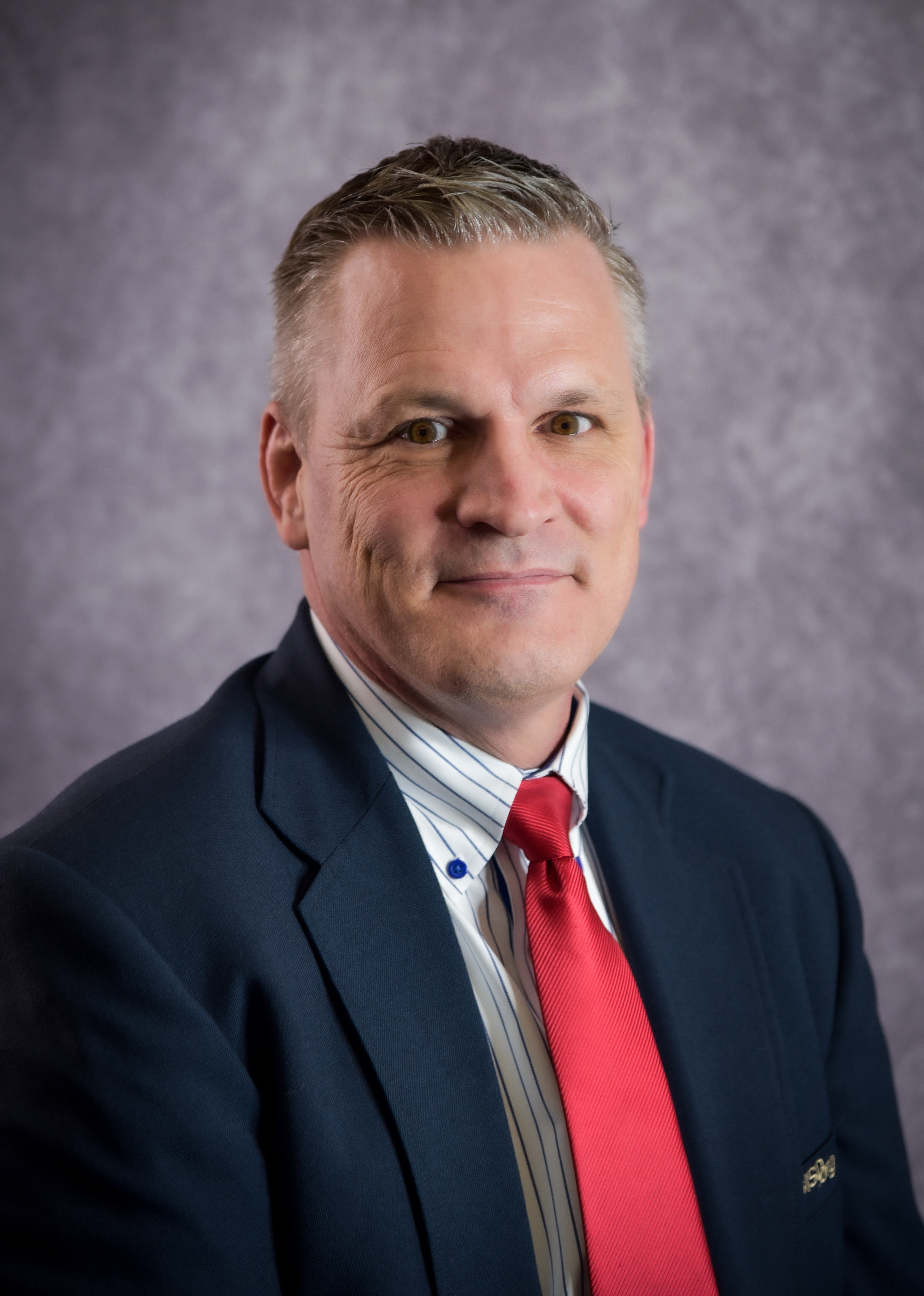 Photo of David D. Manson, Superintendent wearing a red tie.