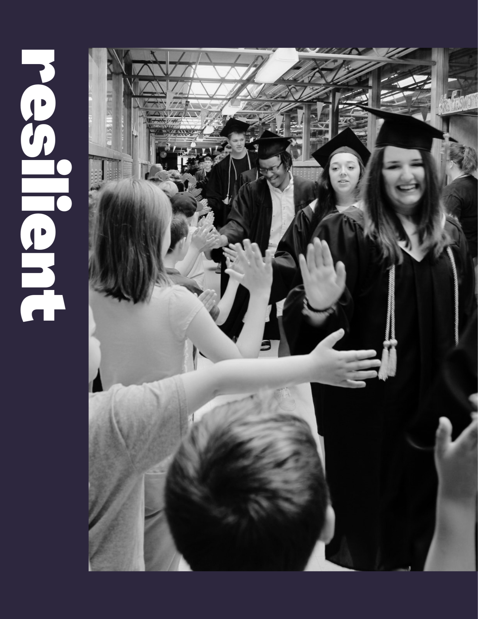 Students in graduation caps and gowns walking down hall