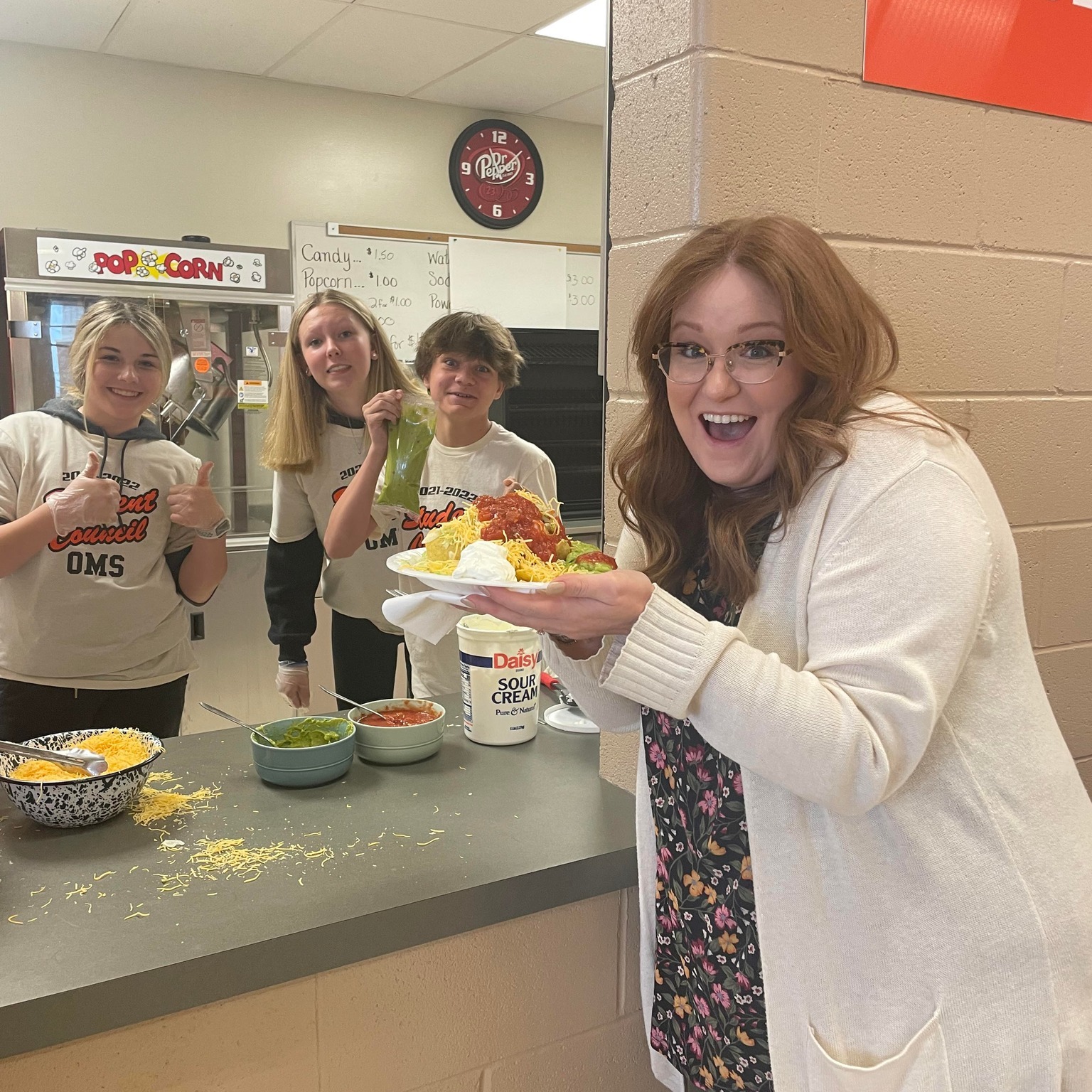 students serving teacher nachos