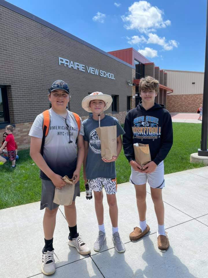 Three students standing outside the school