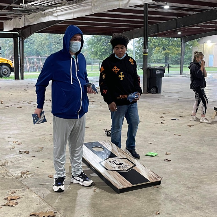 Students playing cornhole.