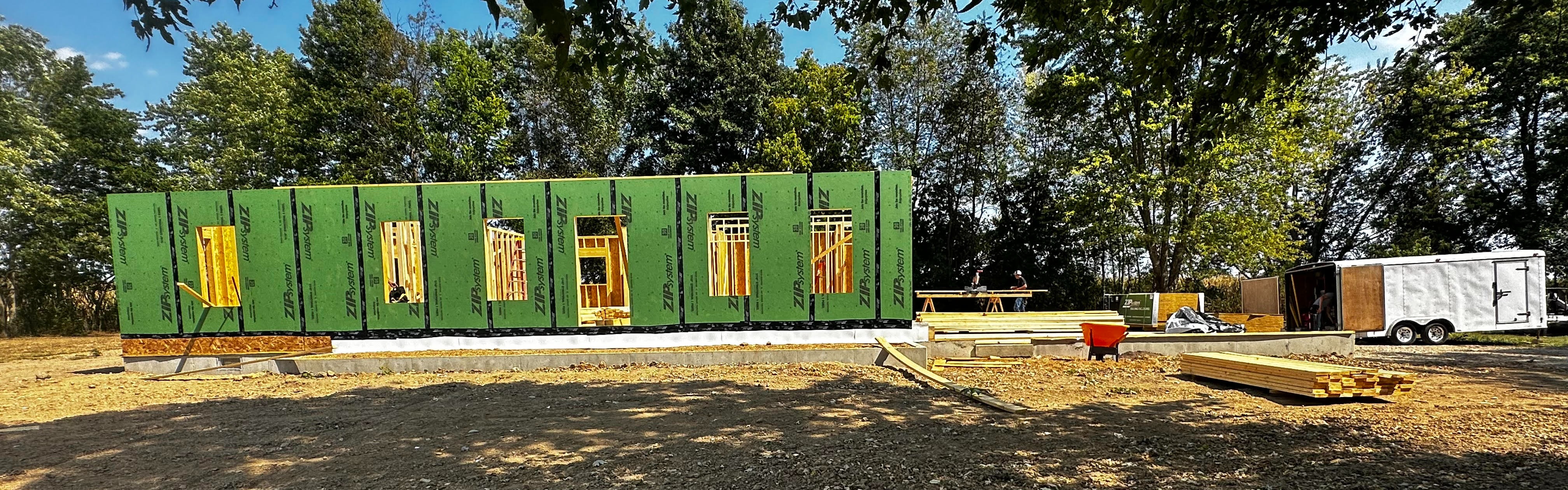 up close picture of student in backwards camouflage hat with welding mask over face using a welding rod to make a weld
