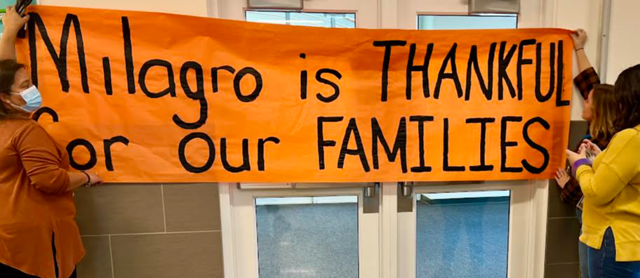 Milagro Middle School Principal, Georgia Baca hangs a welcome sign.