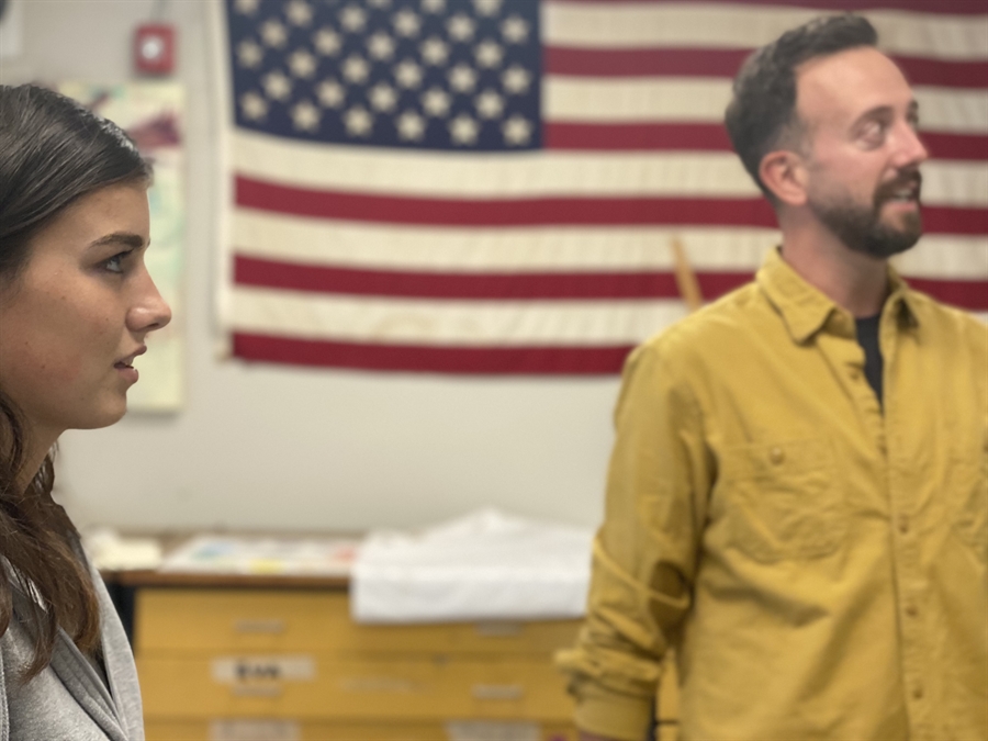 Student and teacher standing in a classroom