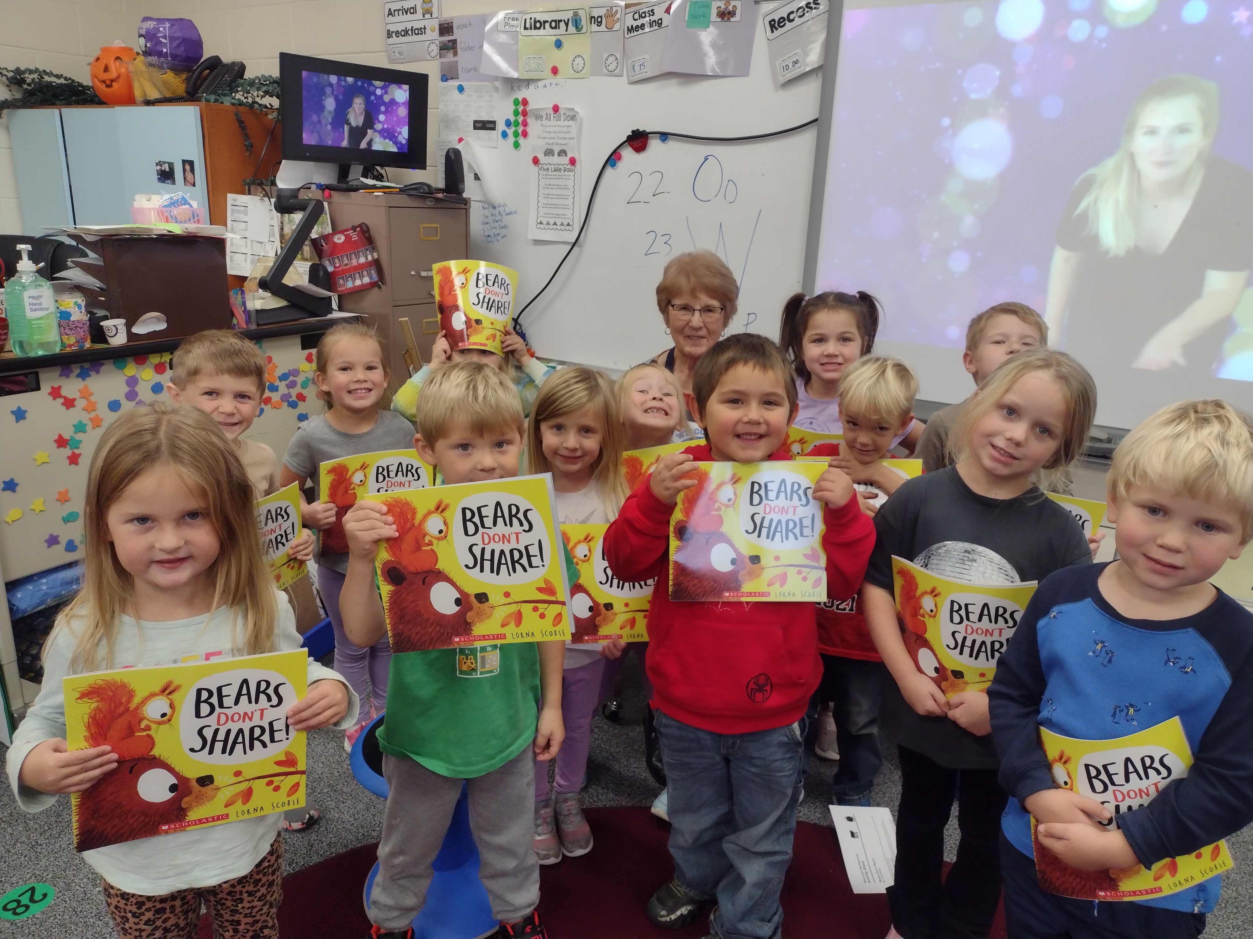 children holding books in a classroom