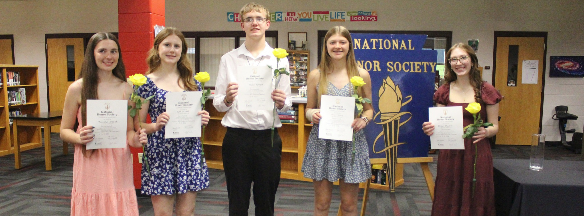 nhs students standing in a line in the library