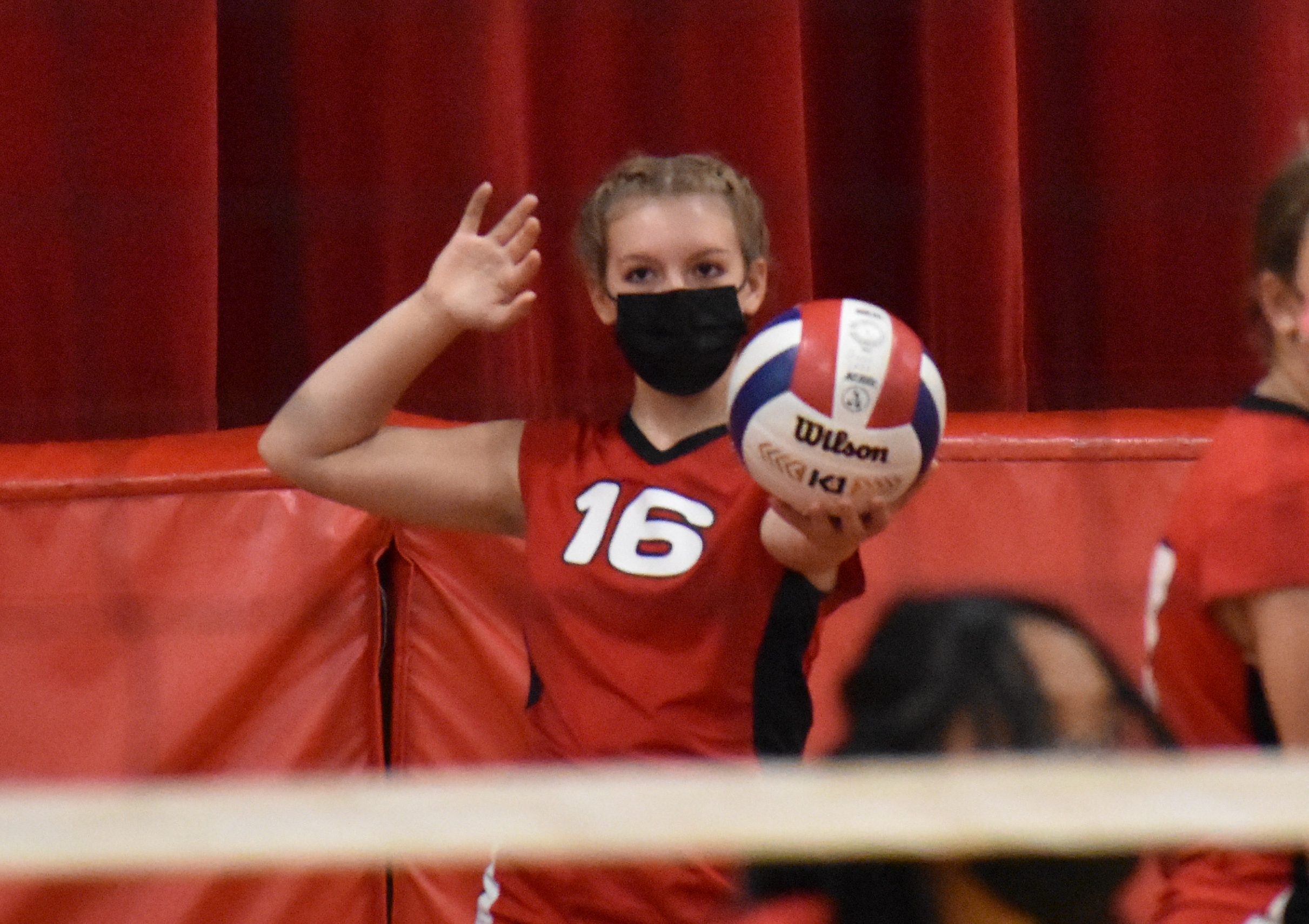 volleyball player gets ready to serve the ball in a game
